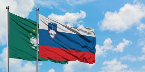 Macao and Slovenia flag waving in the wind against white cloudy blue sky together. Diplomacy concept, international relations.