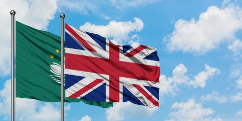 Macao and United Kingdom flag waving in the wind against white cloudy blue sky together. Diplomacy concept, international relations.