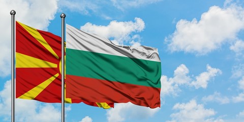 Macedonia and Bulgaria flag waving in the wind against white cloudy blue sky together. Diplomacy concept, international relations.