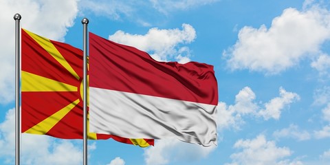 Macedonia and Monaco flag waving in the wind against white cloudy blue sky together. Diplomacy concept, international relations.