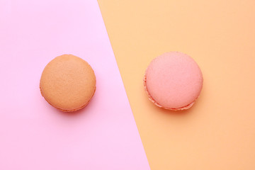 Different tasty macarons on color background
