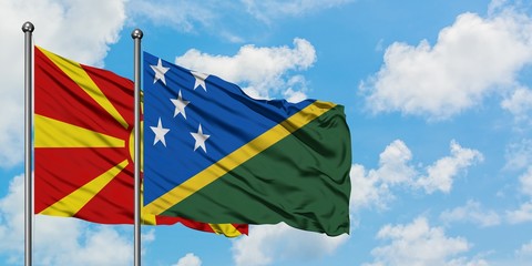 Macedonia and Solomon Islands flag waving in the wind against white cloudy blue sky together. Diplomacy concept, international relations.