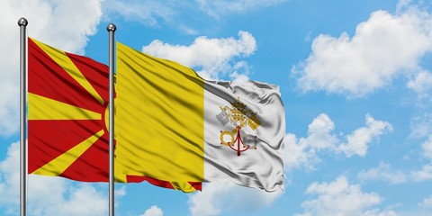 Macedonia and Vatican City flag waving in the wind against white cloudy blue sky together. Diplomacy concept, international relations.