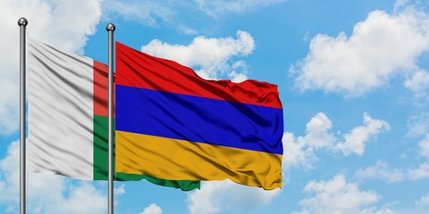 Madagascar and Armenia flag waving in the wind against white cloudy blue sky together. Diplomacy concept, international relations.