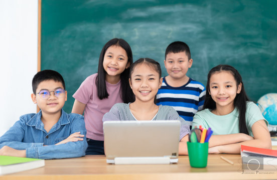 asian children group study in classroom, students feeling happy in education  time, they do work and do project with laptop together on blackboard background, education technology, elementary school
