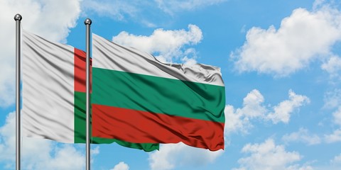 Madagascar and Bulgaria flag waving in the wind against white cloudy blue sky together. Diplomacy concept, international relations.