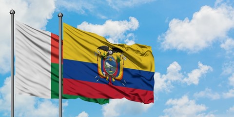 Madagascar and Ecuador flag waving in the wind against white cloudy blue sky together. Diplomacy concept, international relations.