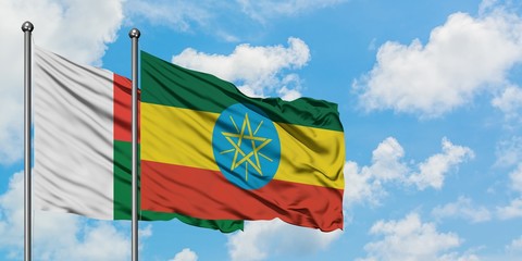 Madagascar and Ethiopia flag waving in the wind against white cloudy blue sky together. Diplomacy concept, international relations.