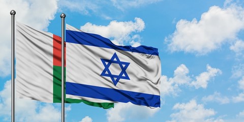 Madagascar and Israel flag waving in the wind against white cloudy blue sky together. Diplomacy concept, international relations.