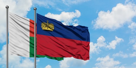 Madagascar and Liechtenstein flag waving in the wind against white cloudy blue sky together. Diplomacy concept, international relations.