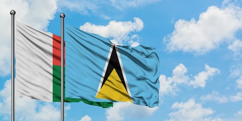 Madagascar and Saint Lucia flag waving in the wind against white cloudy blue sky together. Diplomacy concept, international relations.