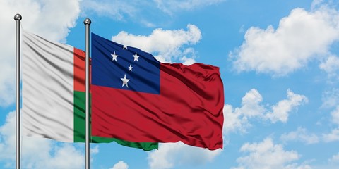 Madagascar and Samoa flag waving in the wind against white cloudy blue sky together. Diplomacy...