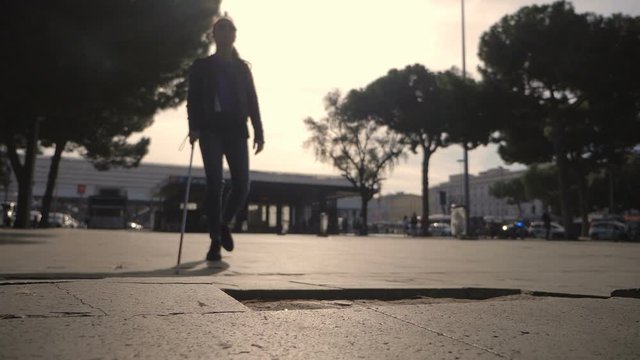 Blind indipendent young woman walking in the city at sunset