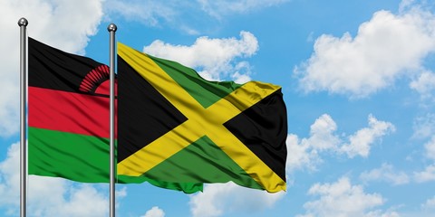 Malawi and Jamaica flag waving in the wind against white cloudy blue sky together. Diplomacy concept, international relations.