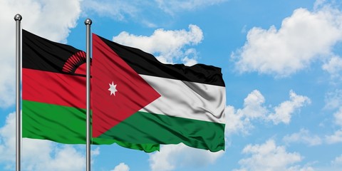 Malawi and Jordan flag waving in the wind against white cloudy blue sky together. Diplomacy concept, international relations.