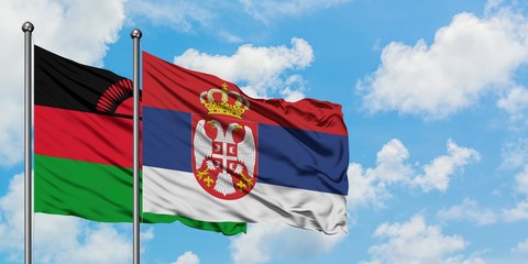 Malawi and Serbia flag waving in the wind against white cloudy blue sky together. Diplomacy concept, international relations.