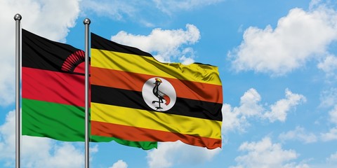 Malawi and Uganda flag waving in the wind against white cloudy blue sky together. Diplomacy concept, international relations.
