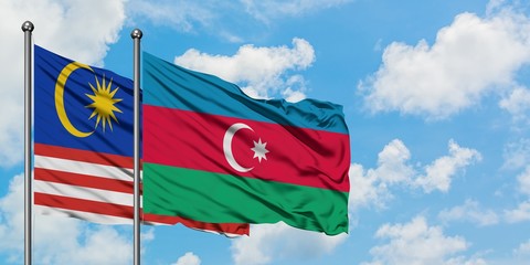 Malaysia and Azerbaijan flag waving in the wind against white cloudy blue sky together. Diplomacy concept, international relations.
