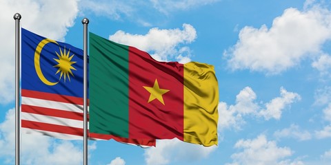 Malaysia and Cameroon flag waving in the wind against white cloudy blue sky together. Diplomacy concept, international relations.