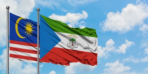 Malaysia and Equatorial Guinea flag waving in the wind against white cloudy blue sky together. Diplomacy concept, international relations.