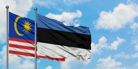 Malaysia and Estonia flag waving in the wind against white cloudy blue sky together. Diplomacy concept, international relations.