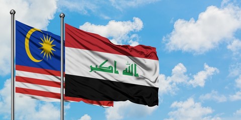 Malaysia and Iraq flag waving in the wind against white cloudy blue sky together. Diplomacy concept, international relations.