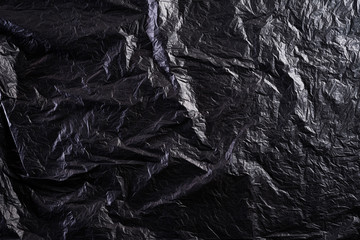 Top view of Black plastic bag texture and background. Reduction of plastic bags for natural treatment. Recycle and World Environment Day concept. - obrazy, fototapety, plakaty