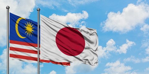 Malaysia and Japan flag waving in the wind against white cloudy blue sky together. Diplomacy concept, international relations.