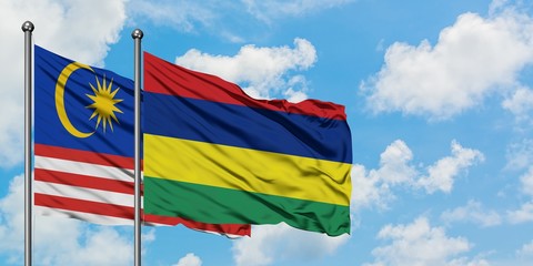 Malaysia and Mauritius flag waving in the wind against white cloudy blue sky together. Diplomacy concept, international relations.