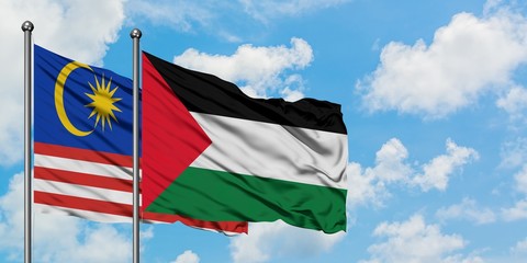 Malaysia and Palestine flag waving in the wind against white cloudy blue sky together. Diplomacy concept, international relations.
