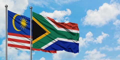 Malaysia and South Africa flag waving in the wind against white cloudy blue sky together. Diplomacy concept, international relations.