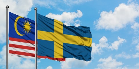 Malaysia and Sweden flag waving in the wind against white cloudy blue sky together. Diplomacy concept, international relations.