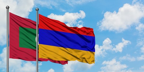 Maldives and Armenia flag waving in the wind against white cloudy blue sky together. Diplomacy concept, international relations.