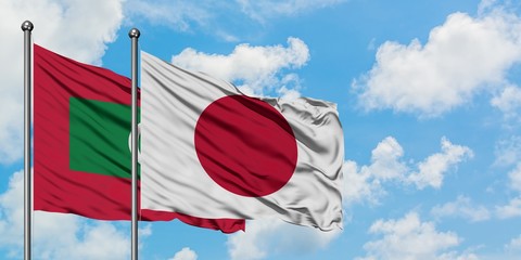 Maldives and Japan flag waving in the wind against white cloudy blue sky together. Diplomacy concept, international relations.