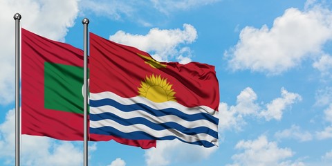 Maldives and Kiribati flag waving in the wind against white cloudy blue sky together. Diplomacy concept, international relations.