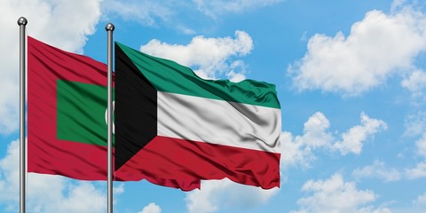 Maldives and Kuwait flag waving in the wind against white cloudy blue sky together. Diplomacy concept, international relations.