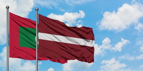 Maldives and Latvia flag waving in the wind against white cloudy blue sky together. Diplomacy concept, international relations.