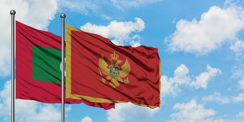 Maldives and Montenegro flag waving in the wind against white cloudy blue sky together. Diplomacy concept, international relations.