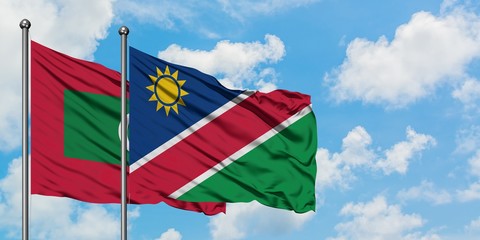 Maldives and Namibia flag waving in the wind against white cloudy blue sky together. Diplomacy concept, international relations.