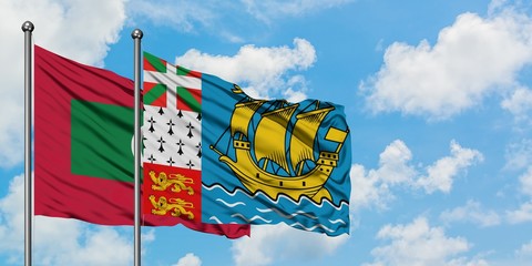 Maldives and Saint Pierre And Miquelon flag waving in the wind against white cloudy blue sky together. Diplomacy concept, international relations.