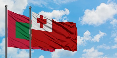 Maldives and Tonga flag waving in the wind against white cloudy blue sky together. Diplomacy concept, international relations.