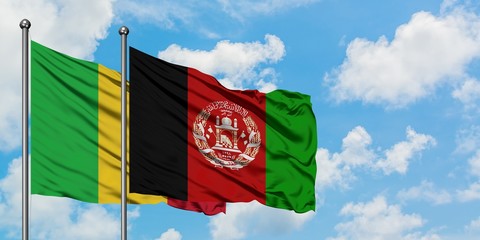 Mali and Afghanistan flag waving in the wind against white cloudy blue sky together. Diplomacy...