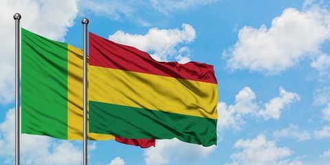 Mali and Bolivia flag waving in the wind against white cloudy blue sky together. Diplomacy concept, international relations.