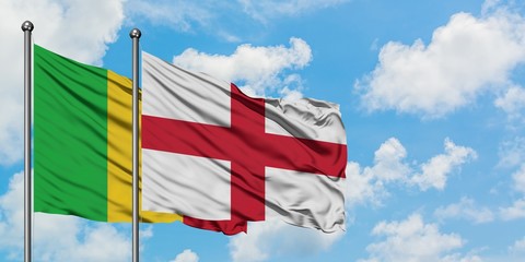 Mali and England flag waving in the wind against white cloudy blue sky together. Diplomacy concept, international relations.