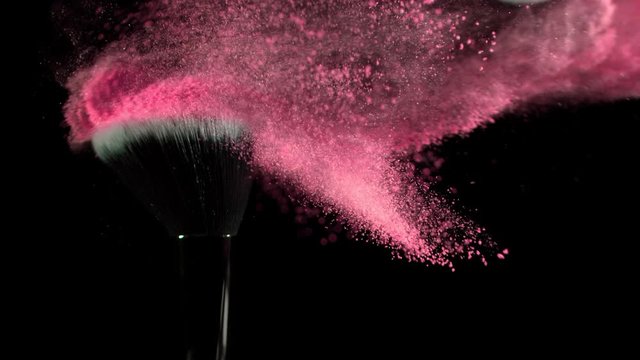 Super Slow Motion Shot of Pink Makeup Powder Falling from Facial Brush at 1000fps.