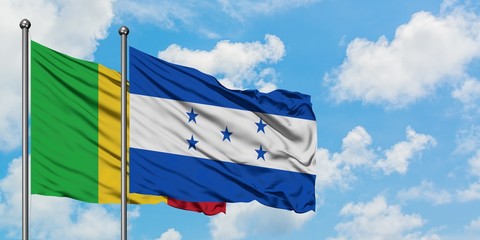 Mali and Honduras flag waving in the wind against white cloudy blue sky together. Diplomacy concept, international relations.