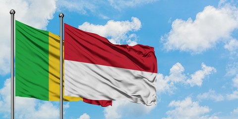 Mali and Indonesia flag waving in the wind against white cloudy blue sky together. Diplomacy concept, international relations.