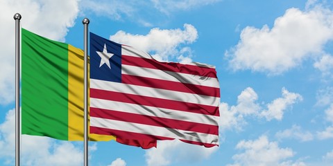 Mali and Liberia flag waving in the wind against white cloudy blue sky together. Diplomacy concept, international relations.