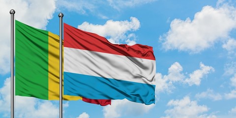 Mali and Luxembourg flag waving in the wind against white cloudy blue sky together. Diplomacy concept, international relations.