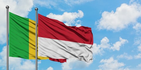 Mali and Monaco flag waving in the wind against white cloudy blue sky together. Diplomacy concept, international relations.